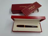 une boîte rouge contenant un stylo, posée sur une table