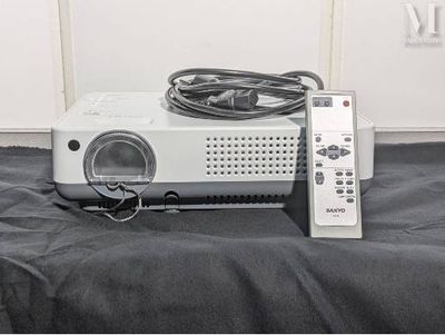 an image of a projector and remote control on a bed