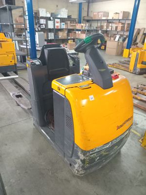 a forklift in a warehouse with pallets in the background