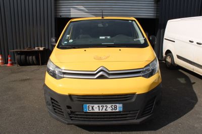 yellow citroen van parked in front of a building next to a white van