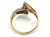 a close up of a gold ring with a green stone in it