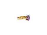 a close up of a gold ring with a purple stone