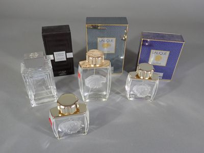 four small bottles of perfume sitting next to each other on a table