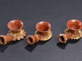 three small vases sitting on top of a table next to each other