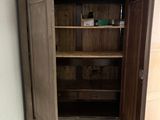 a wooden cabinet with a door open in a room