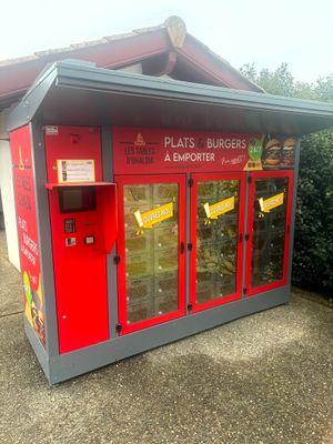 un distributeur automatique rouge installé à l'extérieur d'un immeuble