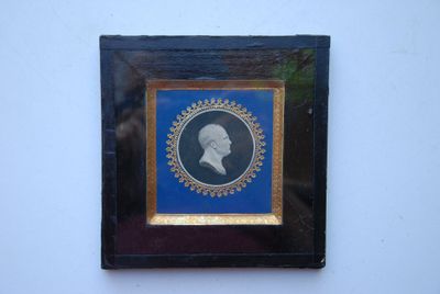 une vieille photo d'un homme dans un cadre bleu et or