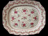a white plate with pink flowers on it on a black background
