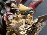 a statue of a man riding a dragon with two people on it