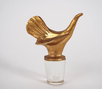 a glass vase with a gold bird on top of it