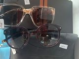 une paire de lunettes de soleil exposée dans la vitrine d'un magasin, accompagnée d'un étui