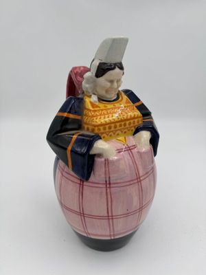 une figurine représentant un homme assis sur un tonneau