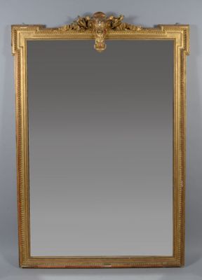 a gold framed mirror with a lion head on the top of it