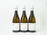 trois bouteilles de vin posées sur une table blanche