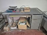 a metal workbench with a bunch of boxes on it