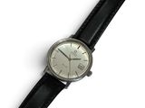 a watch that is sitting on a black leather strap