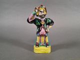 figurine représentant un homme coiffé d'un chapeau et d'un perroquet sur la tête