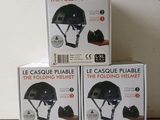three boxes of helmets sitting on top of each other on a table