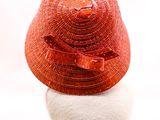 un chapeau rouge posé sur une tête de mannequin