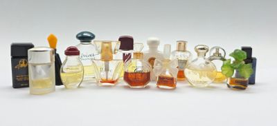 de nombreux flacons de parfum de toutes sortes posés sur une surface blanche