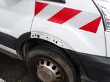 a white van with red stripes parked in a parking lot