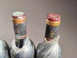 three bottles of wine that are wrapped in plastic