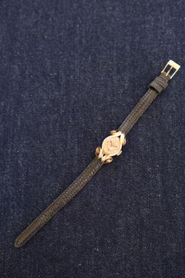 a close up of a watch sitting on top of a blue cloth