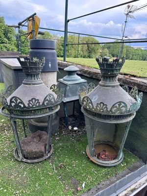two old lanterns sitting on the grass in the back of a truck