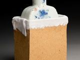 a small blue and white vase sitting in a cardboard box