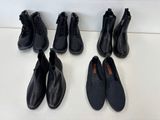 cinq paires de chaussures en cuir noir alignées sur une surface blanche
