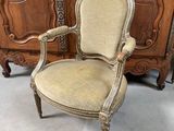 Une vieille chaise est posée devant une grande armoire en bois