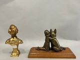 deux figurines en bronze représentant une femme et un enfant, posées sur un socle en bois