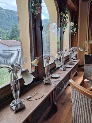 une longue table sur laquelle sont posées de nombreuses lampes, près d'une fenêtre