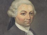 portrait of a man with white hair in a black coat