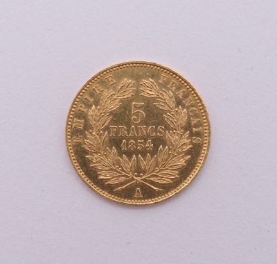gros plan d'une pièce d'or sur une surface blanche