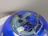 a blue vase with a picture on it sitting on a table