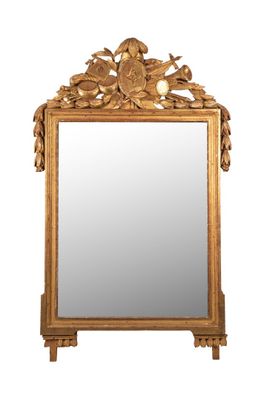 Glace en bois et stuc doré à décor d'étendard, casque, boucl…