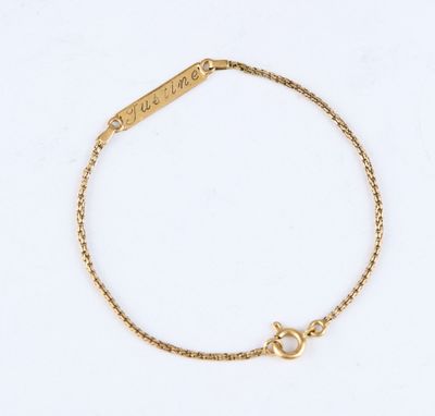 a gold chain bracelet with a heart charm on a white background