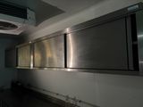 stainless steel cabinets in a commercial kitchen with a fan in the ceiling