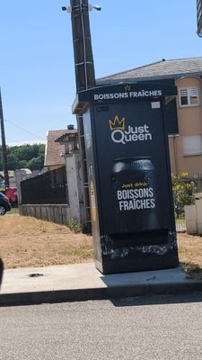une pancarte sur laquelle est simplement écrit « Queen » au bord de la rue