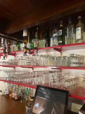 un ordinateur portable posé sur une table devant un mur de verres à vin