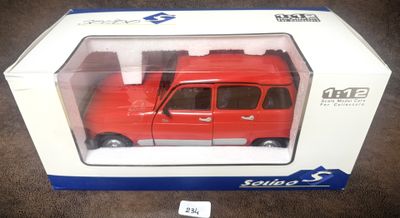 petite voiture rouge dans sa boîte, posée sur une moquette marron