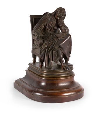 statue en bronze représentant une femme assise sur une chaise avec un chien