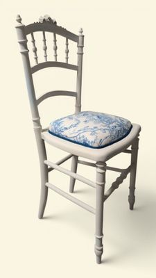 une chaise blanche sur laquelle est posé un coussin bleu