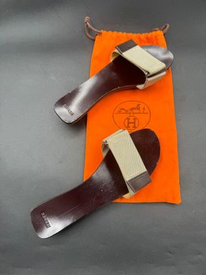 pair of brown leather shoes with orange pouch on grey surface