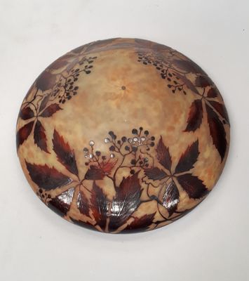 une assiette marron et noire décorée de feuilles et de baies