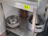 de nombreuses casseroles et poêles posées sur une table en acier inoxydable
