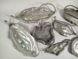 several pieces of silver metal are arranged on a white surface