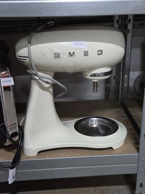 a white mixer sitting on a shelf in a kitchen