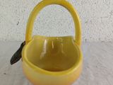 a small yellow bowl with a handle on a table